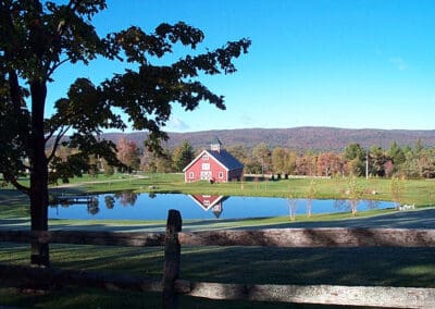 Vermont Wedding Barn set behind pond and wooden fence