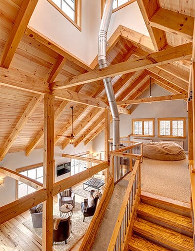 View of loft and timber frame cathedral ceiling above great room.