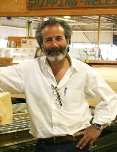 Man in white shirt standing in workshop.