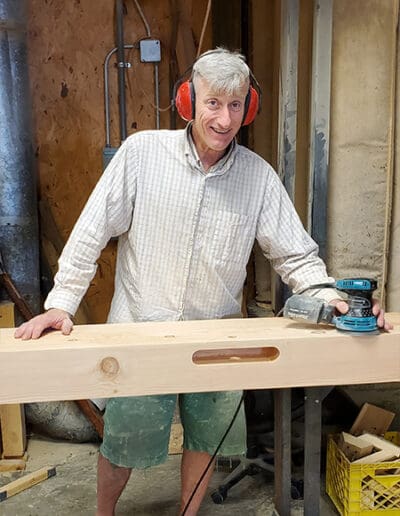 Man working on timber while wearing red ear protection