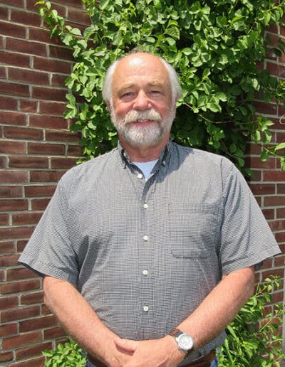 Man standing in front of brick wall.