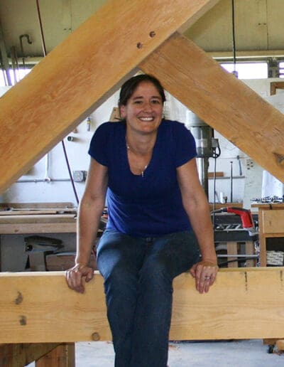 Woman sitting on truss in workshop