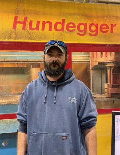 Man standing in front of Hundegger Machine