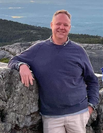 Man leaning against stone wall.